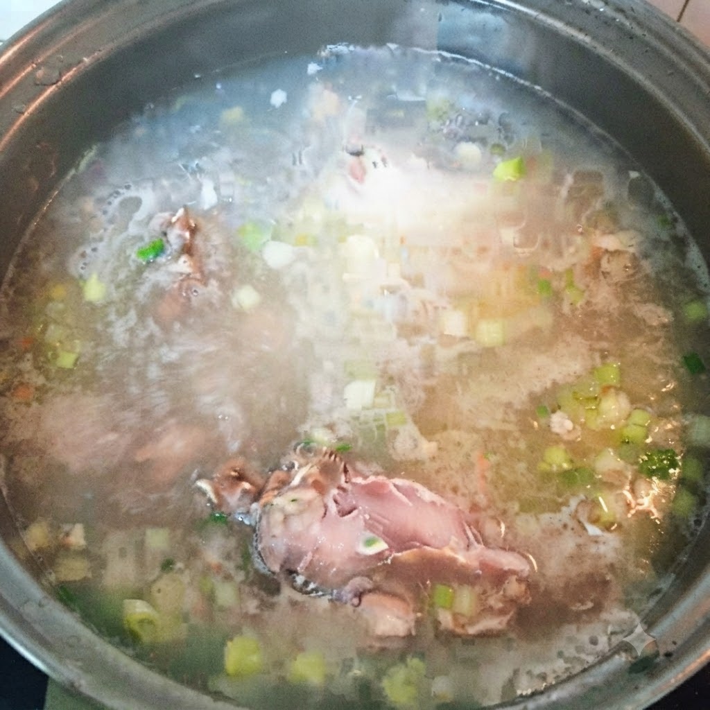 Morceaux de poisson restants ajoutés au bouillon de soupe bouillant.