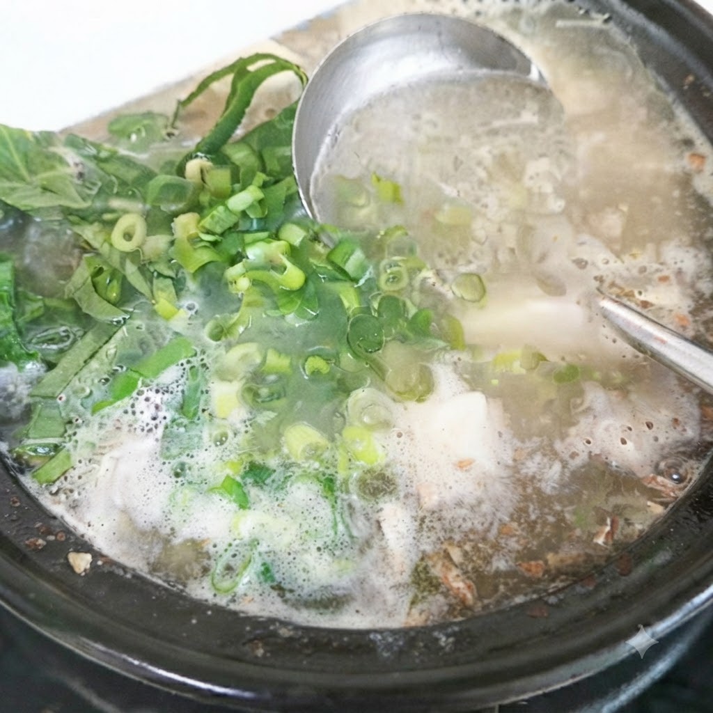 Feuilles de périlla fraîches et oignons verts hachés ajoutés dans la casserole de soupe finie.