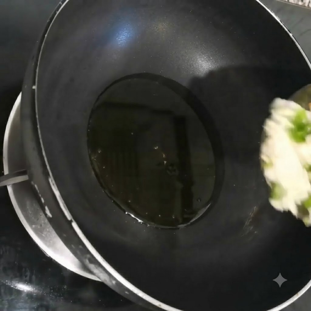 Oignons verts, ail et coriandre finement hachés grésillant dans de lhuile chaude à lintérieur dun wok noir.