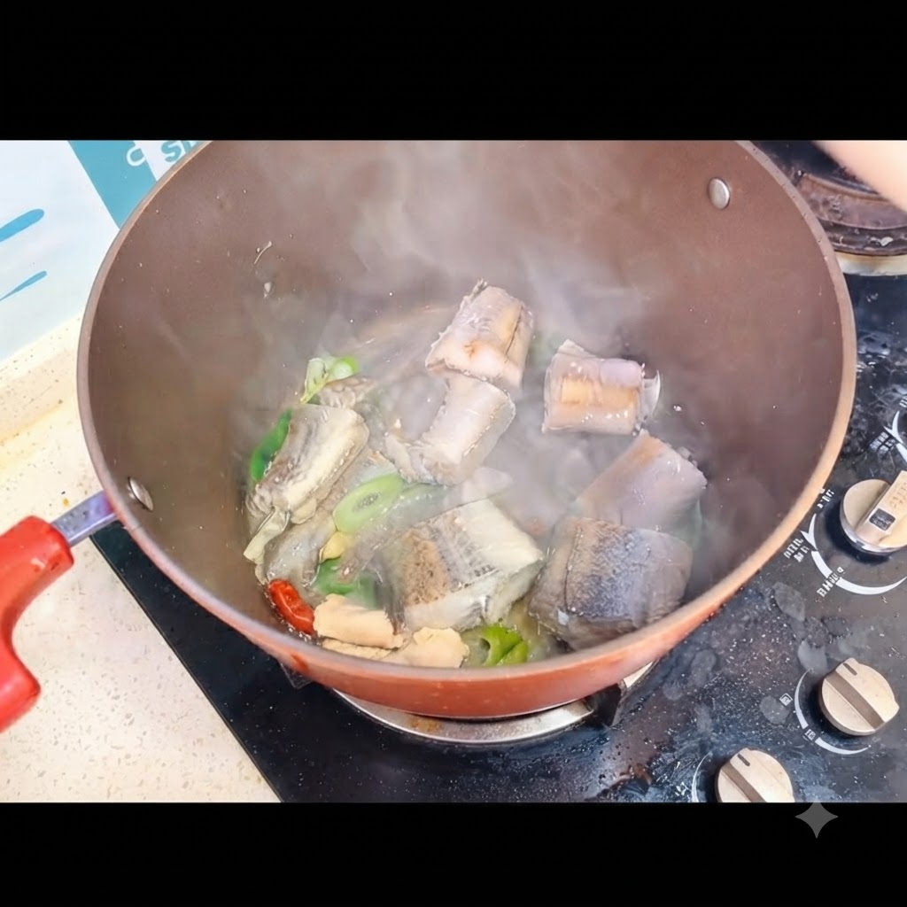 De leau bouillante versée sur les morceaux de poisson dans la marmite sur le feu.