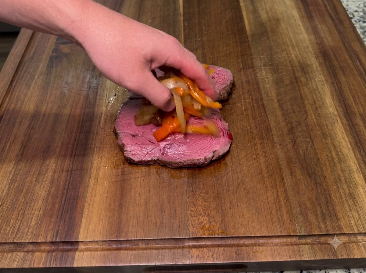 Oignons sautés et piments épicés fumés placés sur un morceau de steak inférieur.