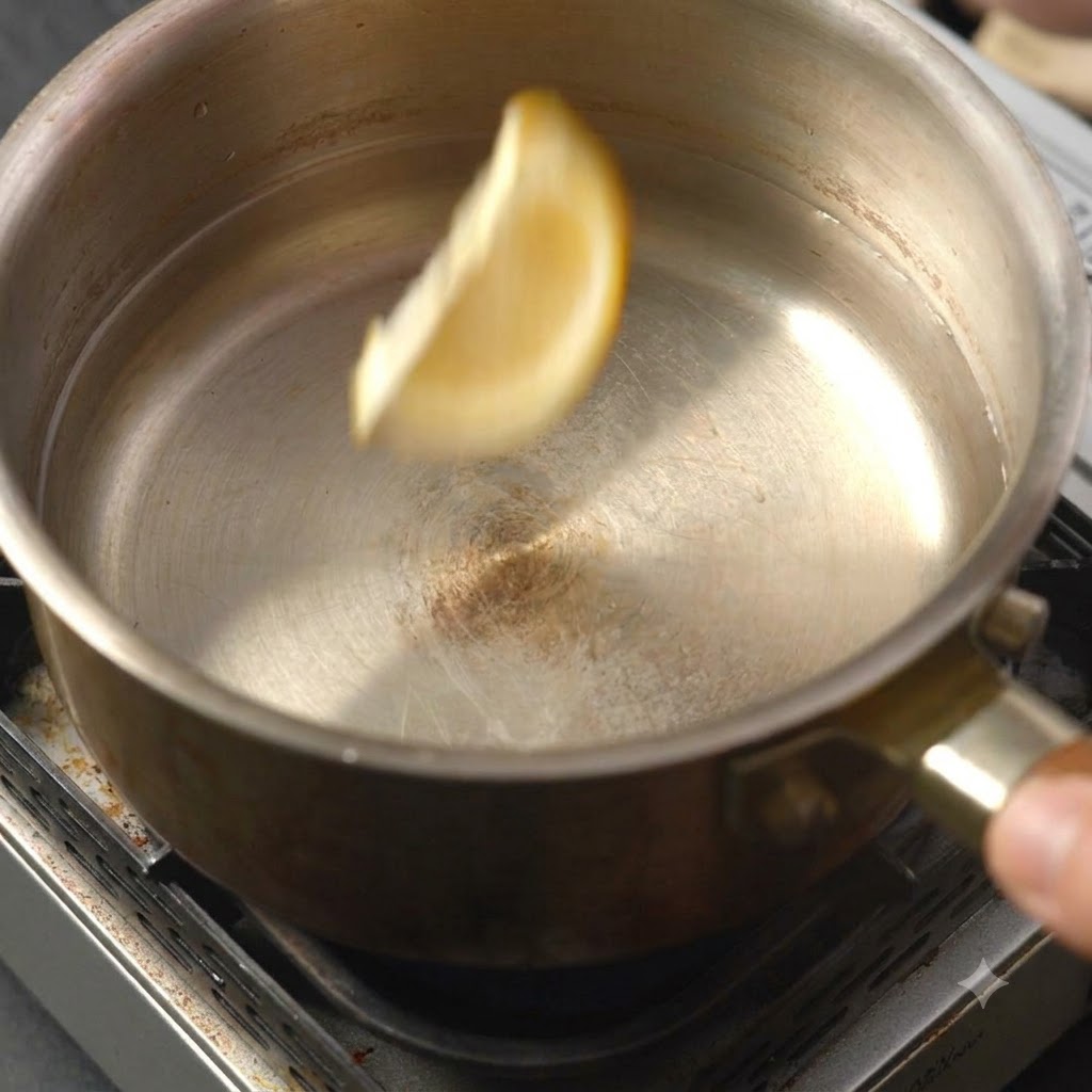 Une seule tranche de citron tombant dans la marmite de liquide.