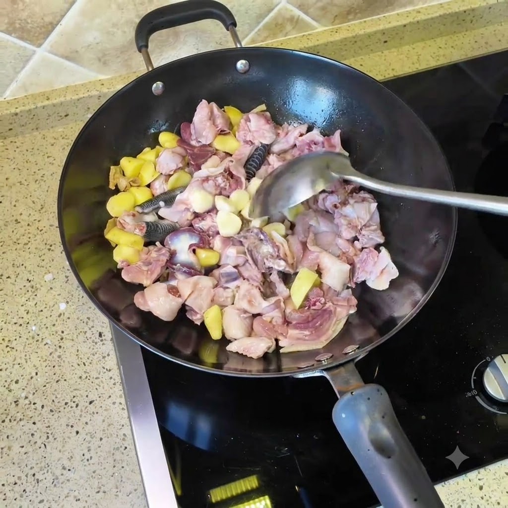Des gousses dail et des piments séchés jetés dans le wok avec le poulet et les morceaux de gingembre.