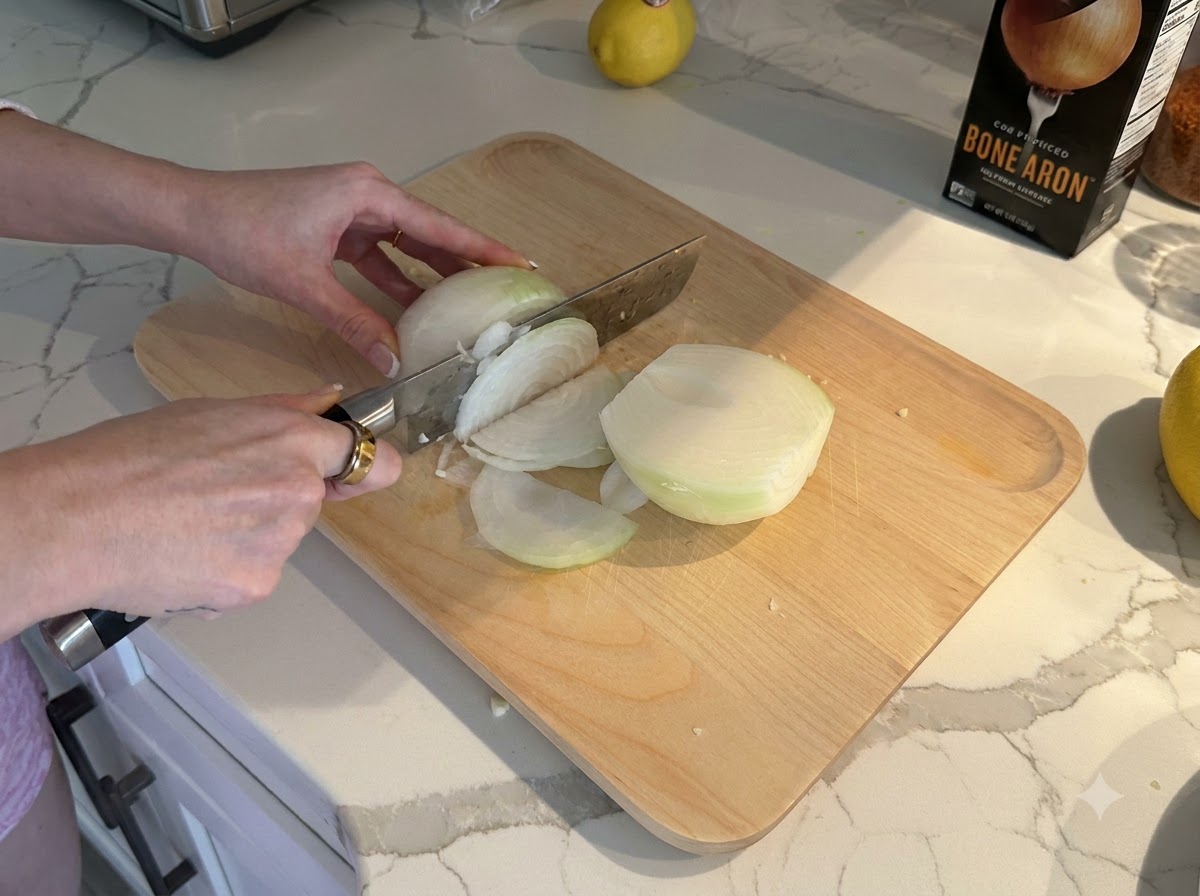 Un oignon blanc coupé et détaillé en petits dés sur une planche à découper en bois.