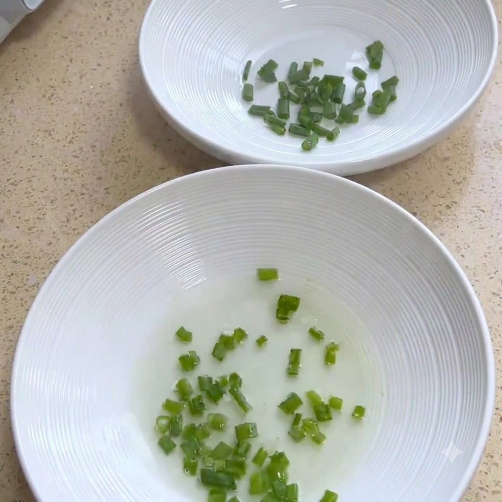 Des bols de service blancs contenant des oignons verts hachés.