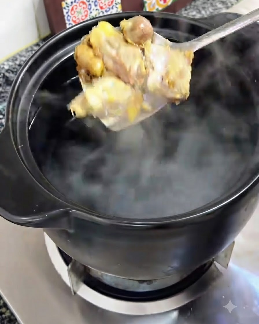 Morceaux de poulet dorés soulevés à la cuillère et transférés dans une cocotte en terre cuite noire remplie deau bouillante.