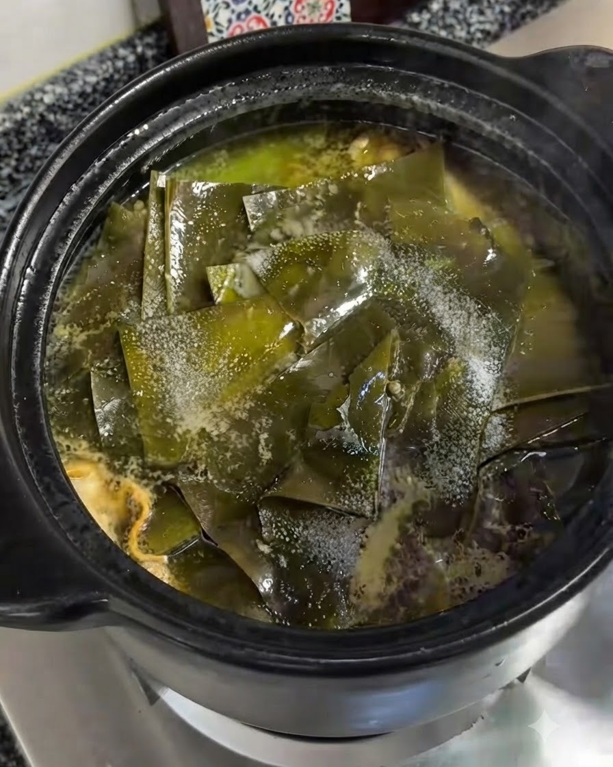 Du sel fin saupoudré directement sur les morceaux dalgues vertes flottant dans la cocotte en terre cuite frémissante.