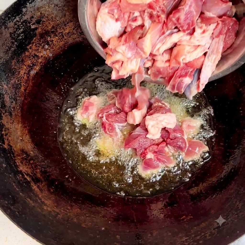 Morceaux de poulet cru versés dun bol en acier dans le wok contenant de lhuile et du gingembre.