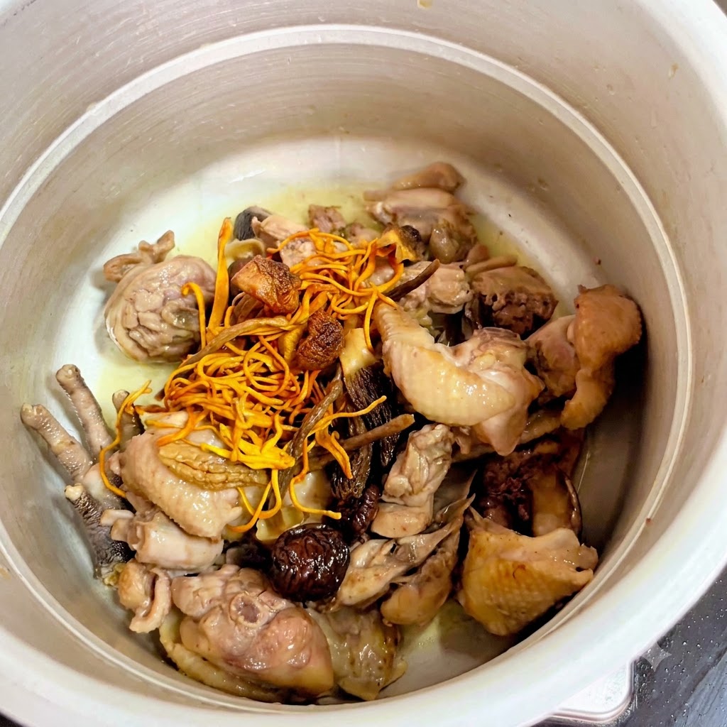 Champignons séchés et fleurs de cordyceps jaunes placés sur le poulet à lintérieur de lautocuiseur.