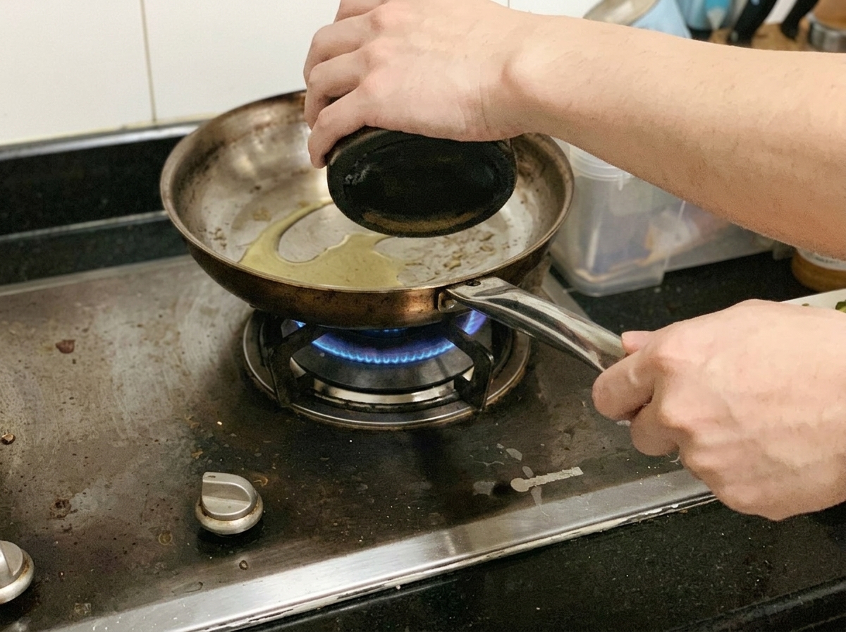 Des morceaux de blanc de poulet en train de cuire et dêtre poivrés dans une poêle sur le feu.