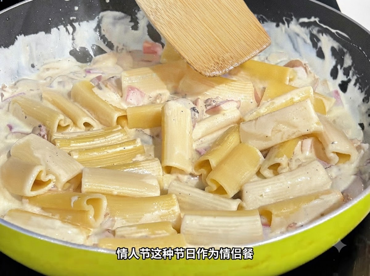 Une spatule en bois remuant des pâtes en forme de cœur dans une sauce crémeuse à lintérieur dune poêle.