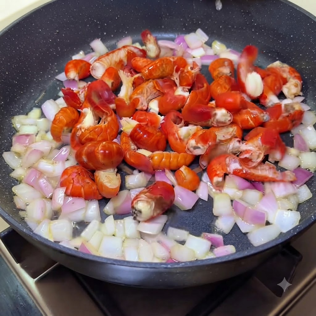 Des queues décrevisses mélangées avec des oignons sautés dans une poêle.