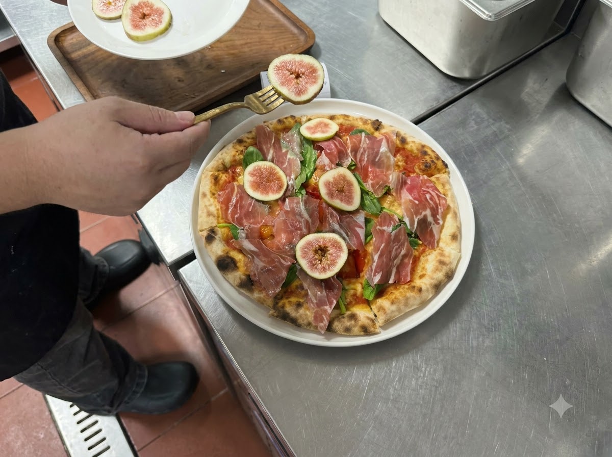 Tranches de figues fraîches et de prosciutto disposées sur une pizza cuite à laide dune fourchette.