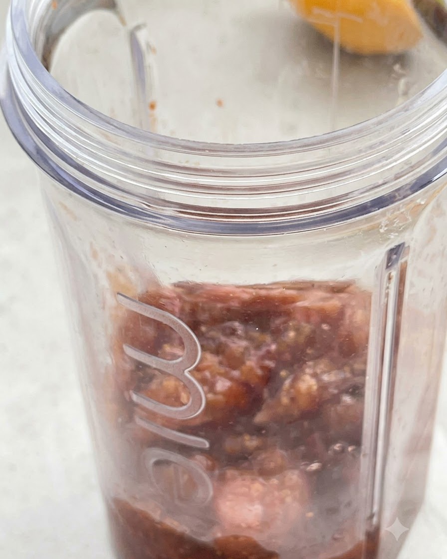 Mélange de figues cuites et crème de coco versés dans un bol de blender transparent.