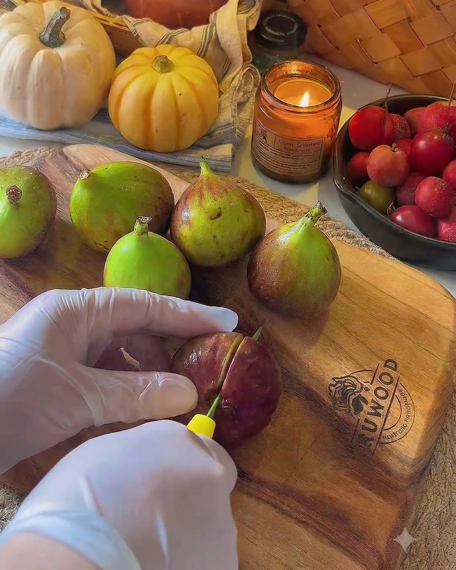 Des figues fraîches coupées en deux sur une planche à découper en bois à laide dun couteau.