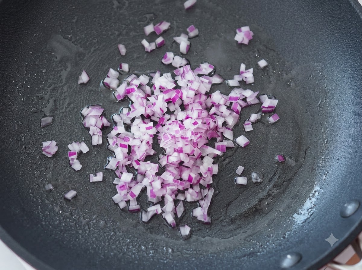 Des oignons violets finement coupés en dés en train dêtre sautés dans une poêle chaude avec de lhuile.