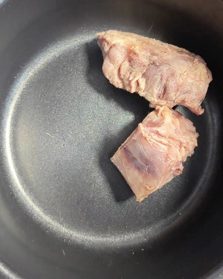 Os de porc rincés à lintérieur de la cuve sombre dun cuiseur de riz.