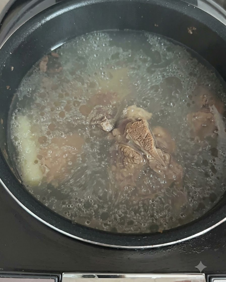 Le bouillon en train de mijoter et de bouillir activement à lintérieur du cuiseur de riz.