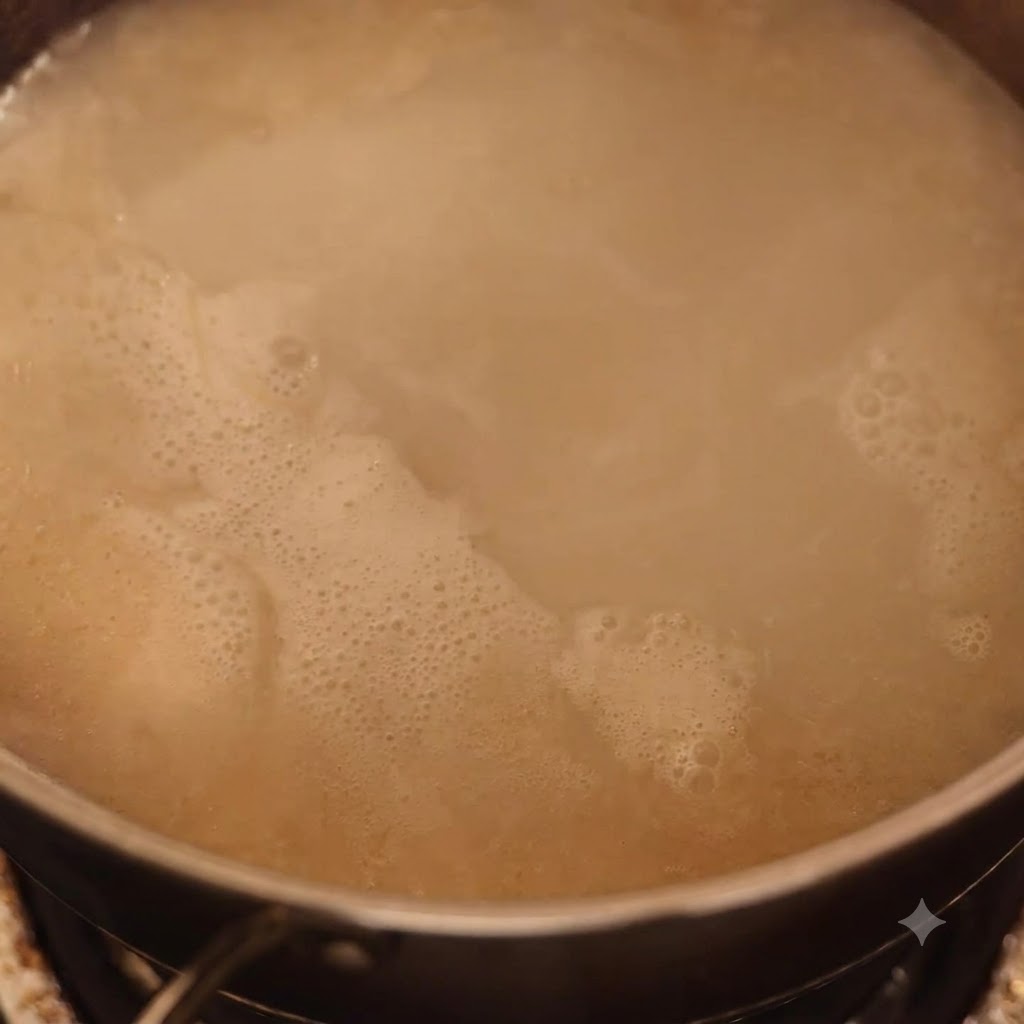 Viande écrasée incorporée dans un bouillon tonkotsu mijotant.