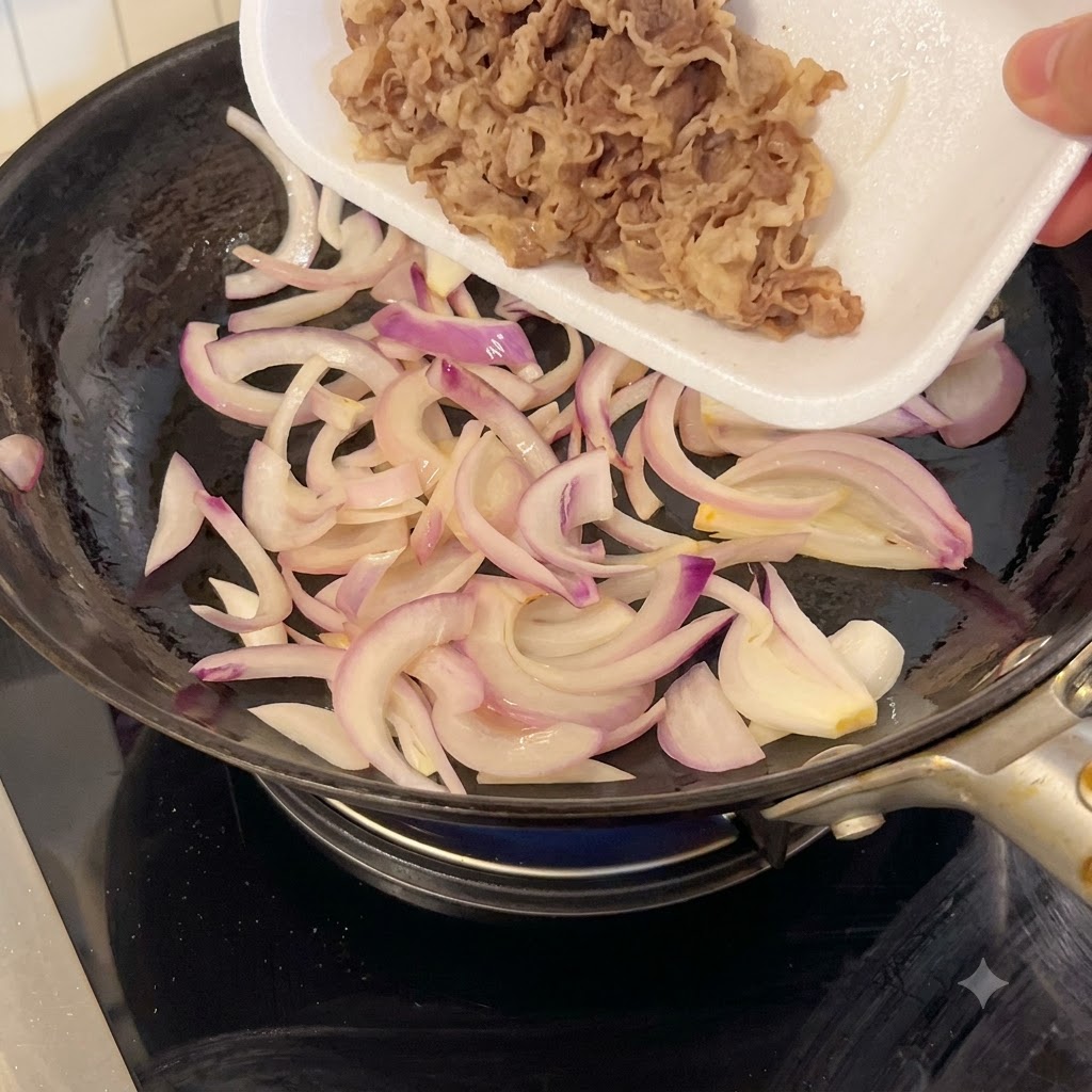 Des tranches de bœuf finement coupées versées dune barquette en mousse blanche dans une poêle contenant des oignons rouges sautés.