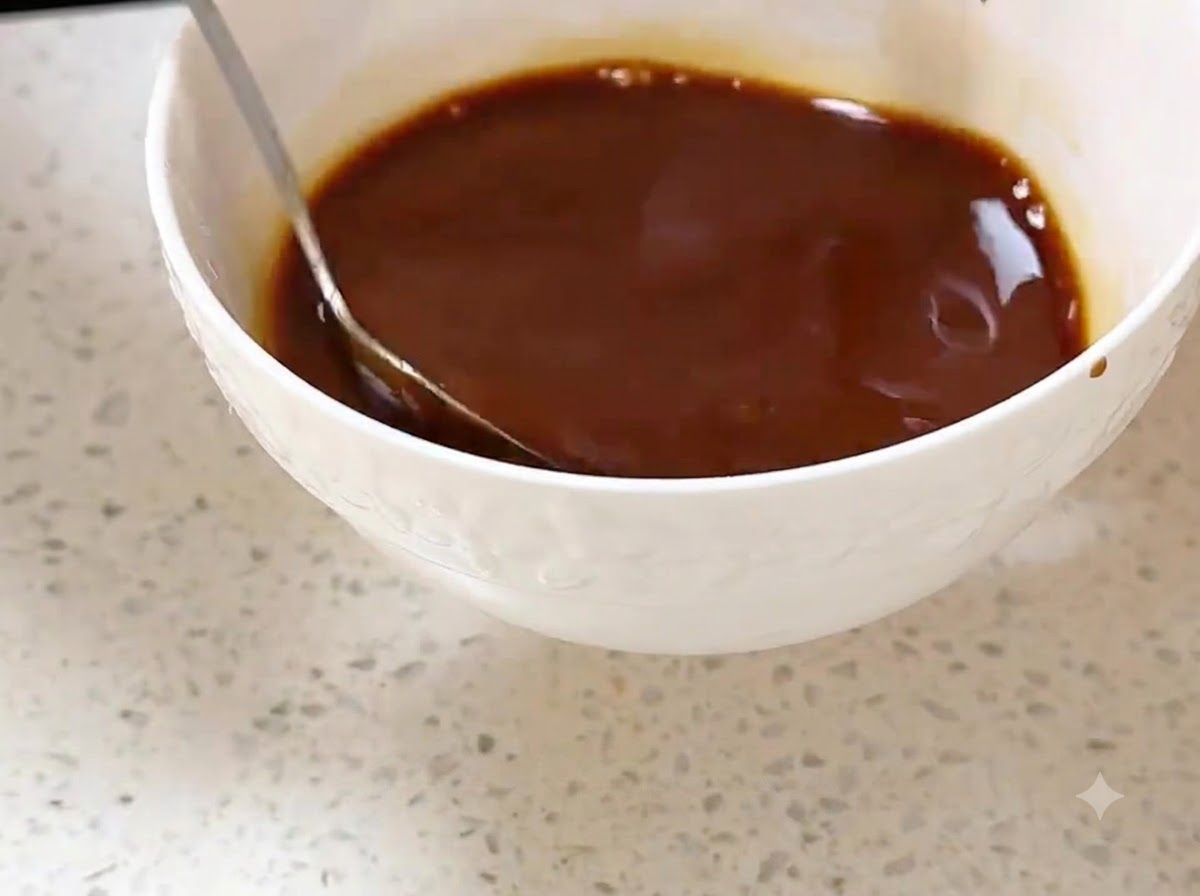 Un cube de beurre fondant dans un wok chaud, étalé à laide dune spatule.