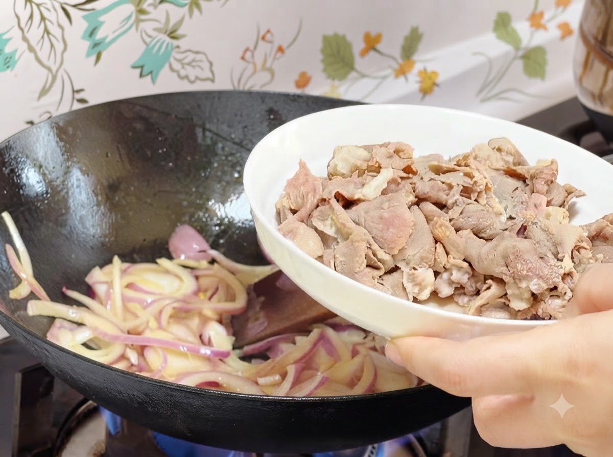 Des rouleaux de bœuf blanchis versés dune assiette blanche dans le wok avec les oignons cuits.