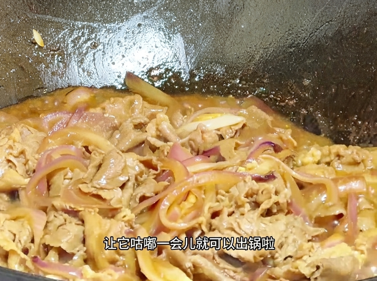 Vue rapprochée du bœuf et des oignons mijotant dans une sauce onctueuse et bouillonnante à lintérieur dun wok.