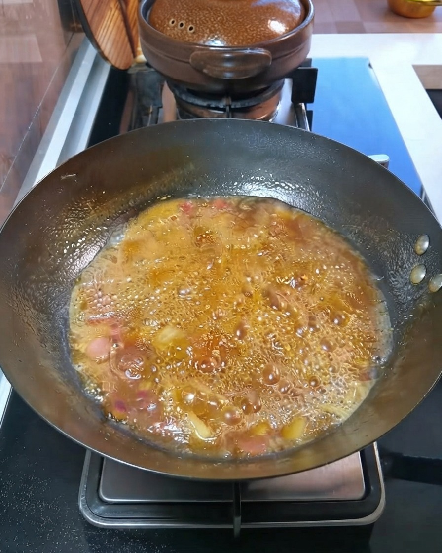 Des pommes de terre et des carottes en dés mijotent dans un bouillon bouillonnant à lintérieur du wok.cite: 1