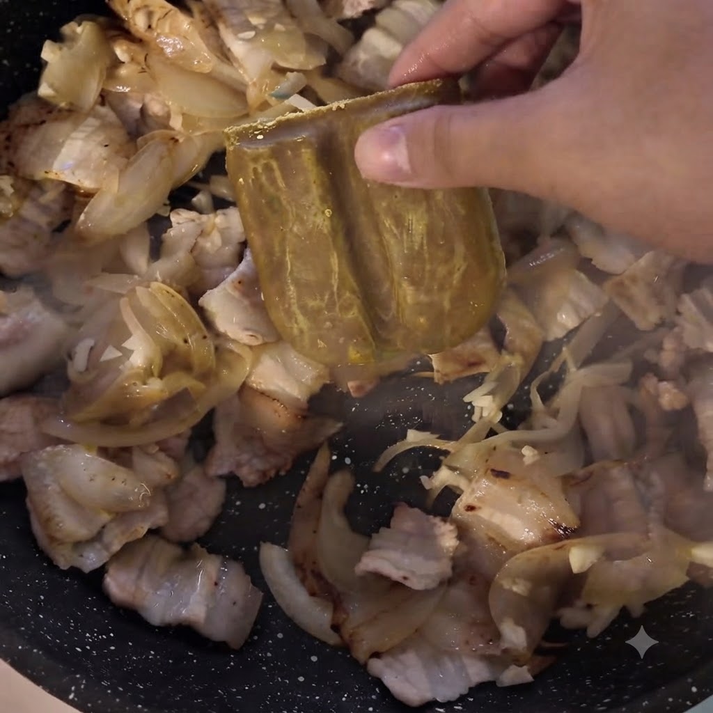 Un bloc de pâte de curry est ajouté dans la poêle contenant la viande et les oignons.
