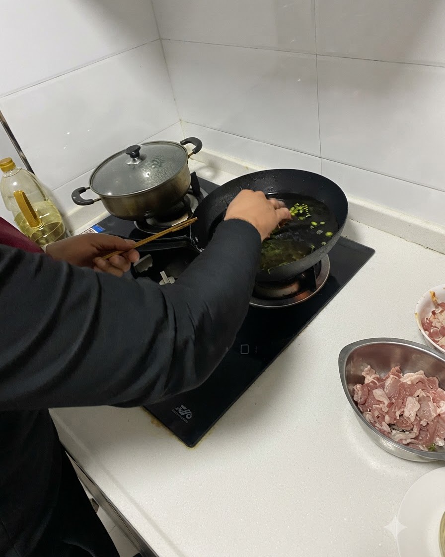 Aromates émincés ajoutés dans lhuile chaude dun wok à laide de baguettes.