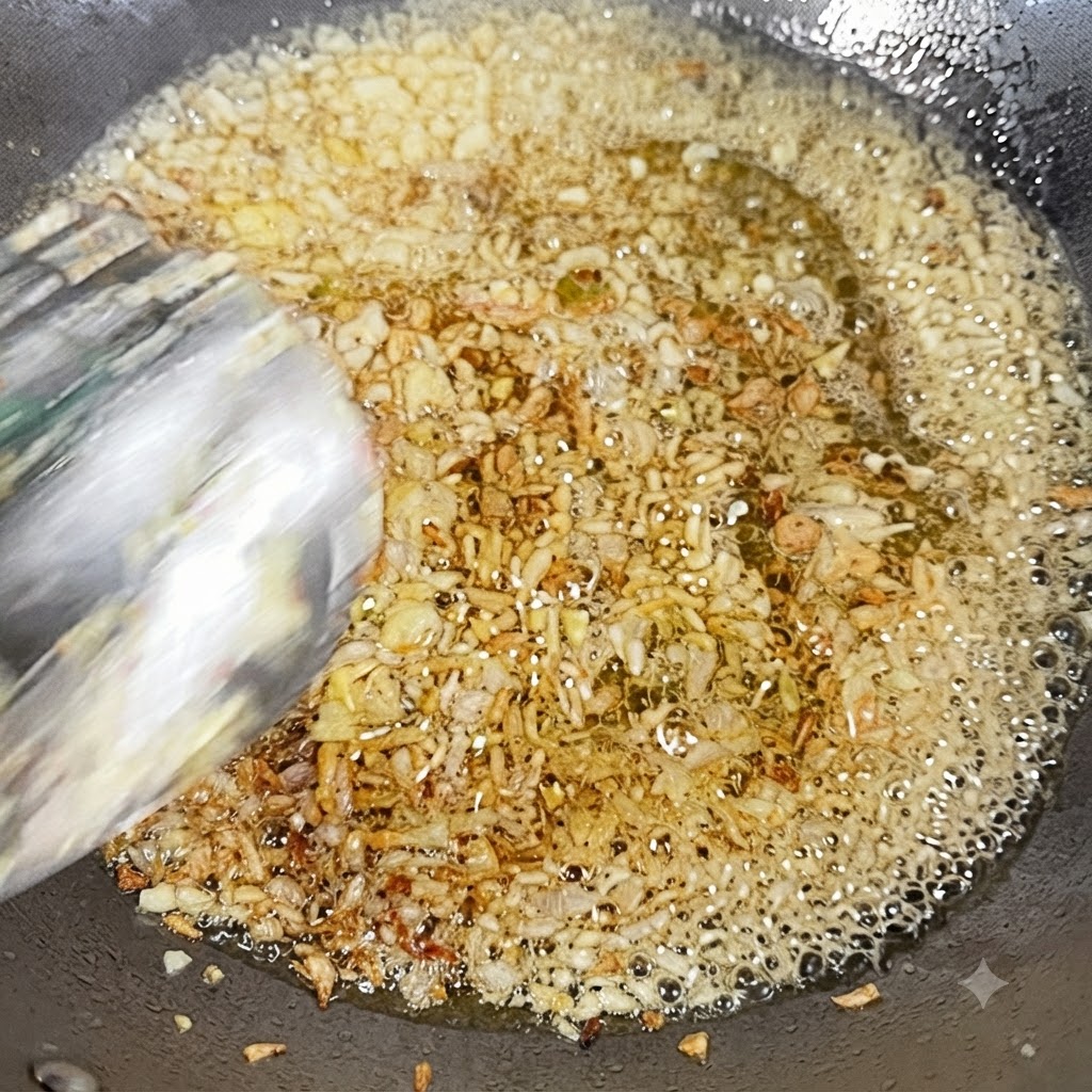 Ail haché et oignon coupé en dés en train de frire dans lhuile chaude dun wok.