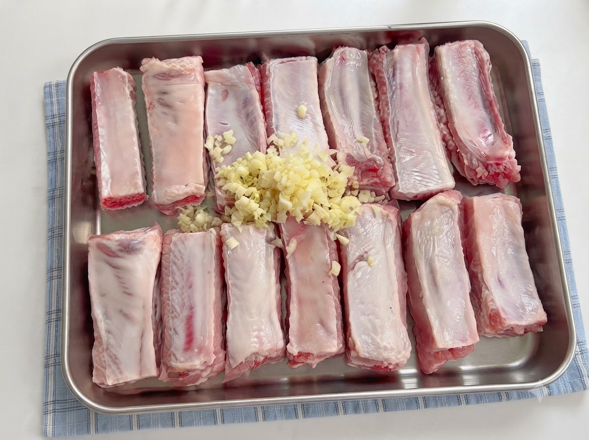 Des sauces versées dune cuillère sur les travers de porc assaisonnés avec de lail émincécite: 1.