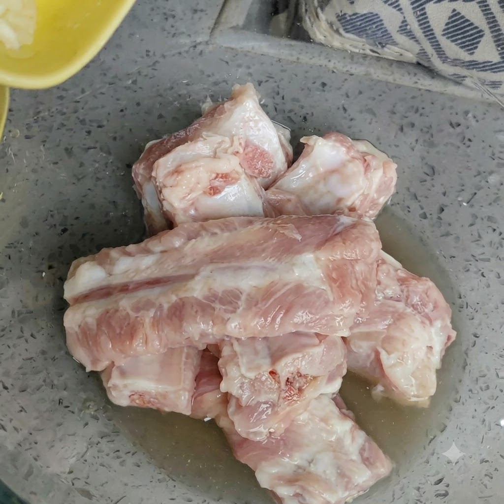 Bol de travers de porc crus garnis dail fraîchement haché.
