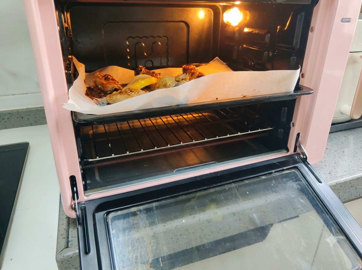 Tranches de citron frais disposées sur la plaque à côté des travers de porc en cours de cuisson.