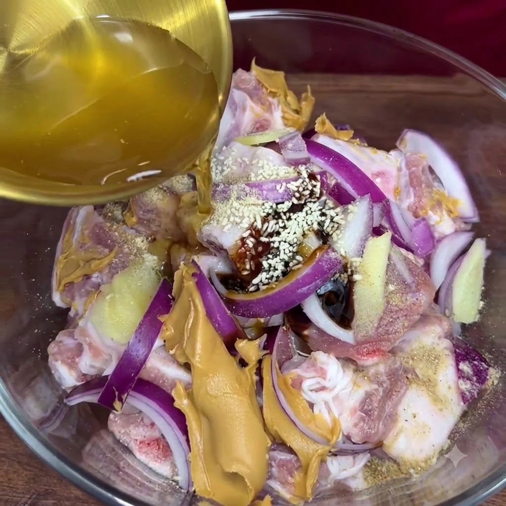 Jus dail doré versé dune louche dans le bol en verre contenant les côtes de porc assaisonnées et les autres ingrédients de la marinade.
