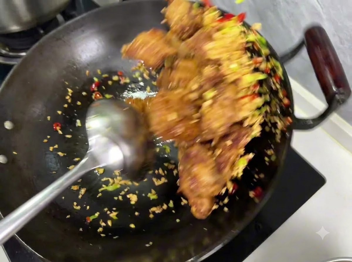 Assaisonnement sel et poivre saupoudré sur le mélange de côtes et dail à lintérieur dun wok.