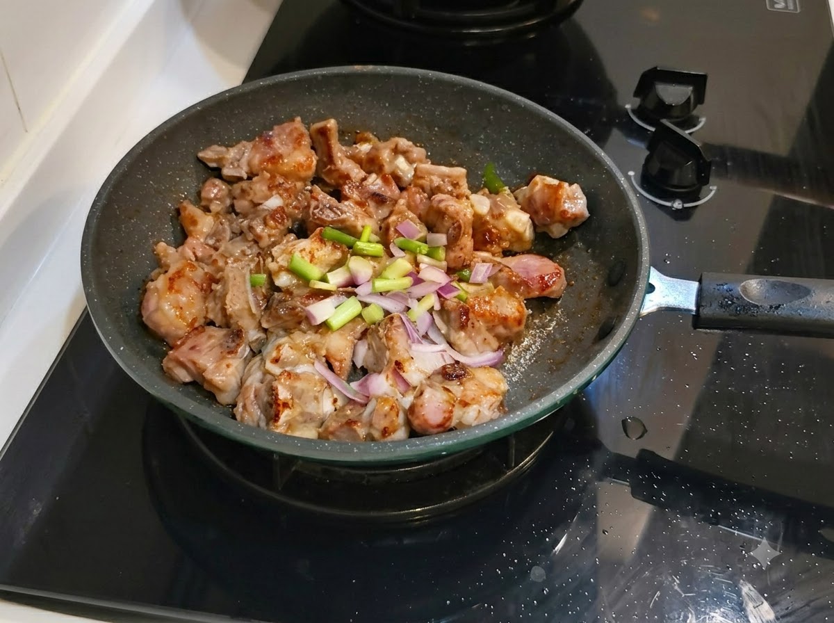 Oignons verts hachés et gingembre étalés sur les côtes de porc dans la poêle à frire.