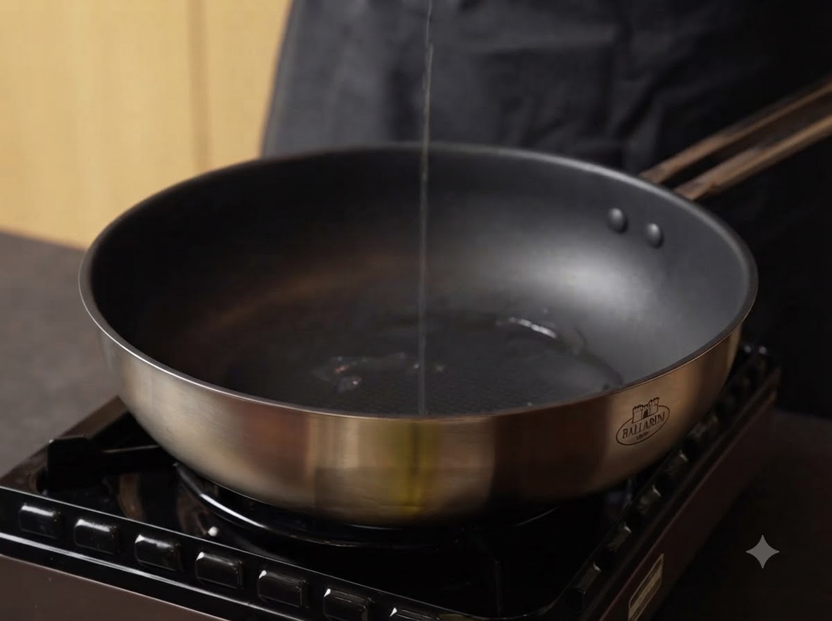 De lhuile versée dans une poêle en acier inoxydable chaude sur une cuisinière.