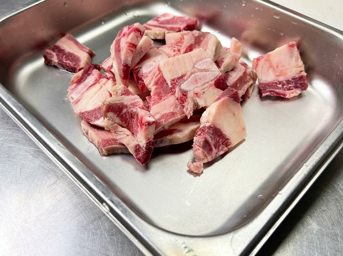Côtes de bœuf crues placées à lintérieur dun récipient métallique propre prêtes pour lassaisonnement.