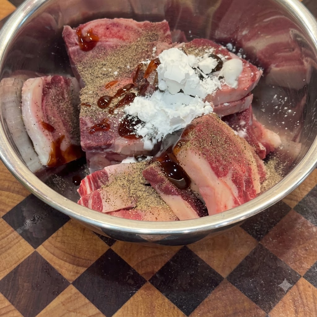 Bœuf cru dans un bol en métal mélangé aux assaisonnements, à la sauce huître et à la fécule de maïs.