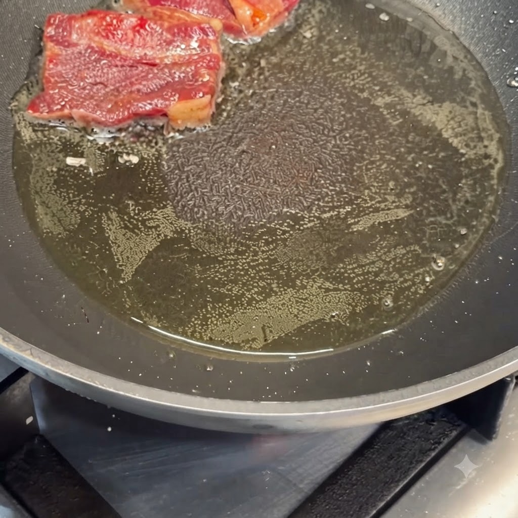 Travers de bœuf marinés en train de grésiller dans lhuile chaude dune poêle.