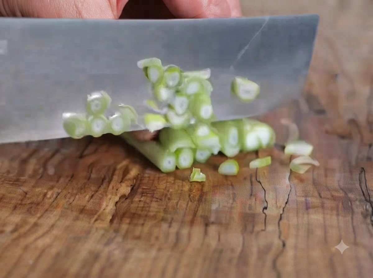 Oignons verts coupés en petits rondelles sur une planche à découper en bois avec un couteau.