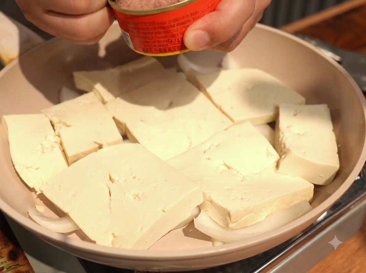 Morceaux de thon en conserve déposés à la cuillère au centre des tranches de tofu.