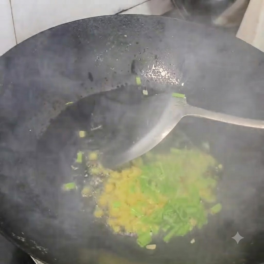 Des oignons verts, du gingembre et de lail émincés en train de revenir dans un wok noir chaud avec une spatule.
