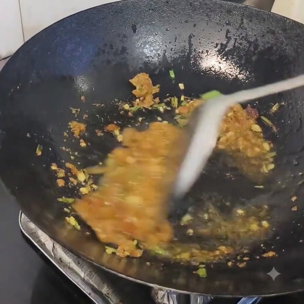 Des résidus de saindoux de porc mélangés aux aromates sautés dans un wok chaud.