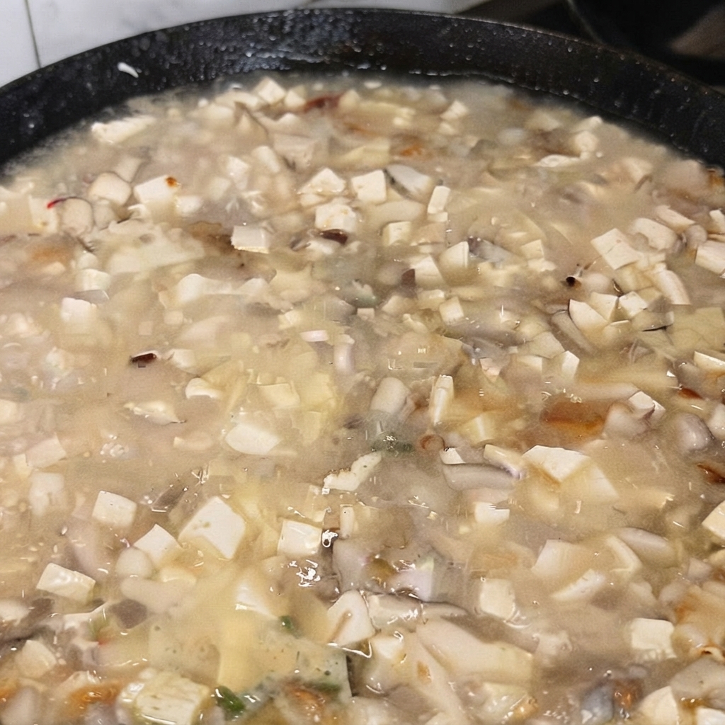 Une cuillère de glutamate monosodique ajoutée à la soupe en train de bouillir.