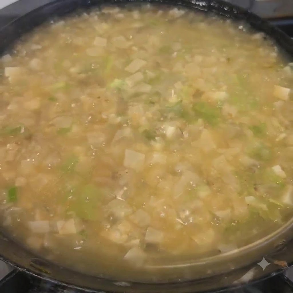 De la coriandre hachée saupoudrée sur la soupe finie dans la cocotte.