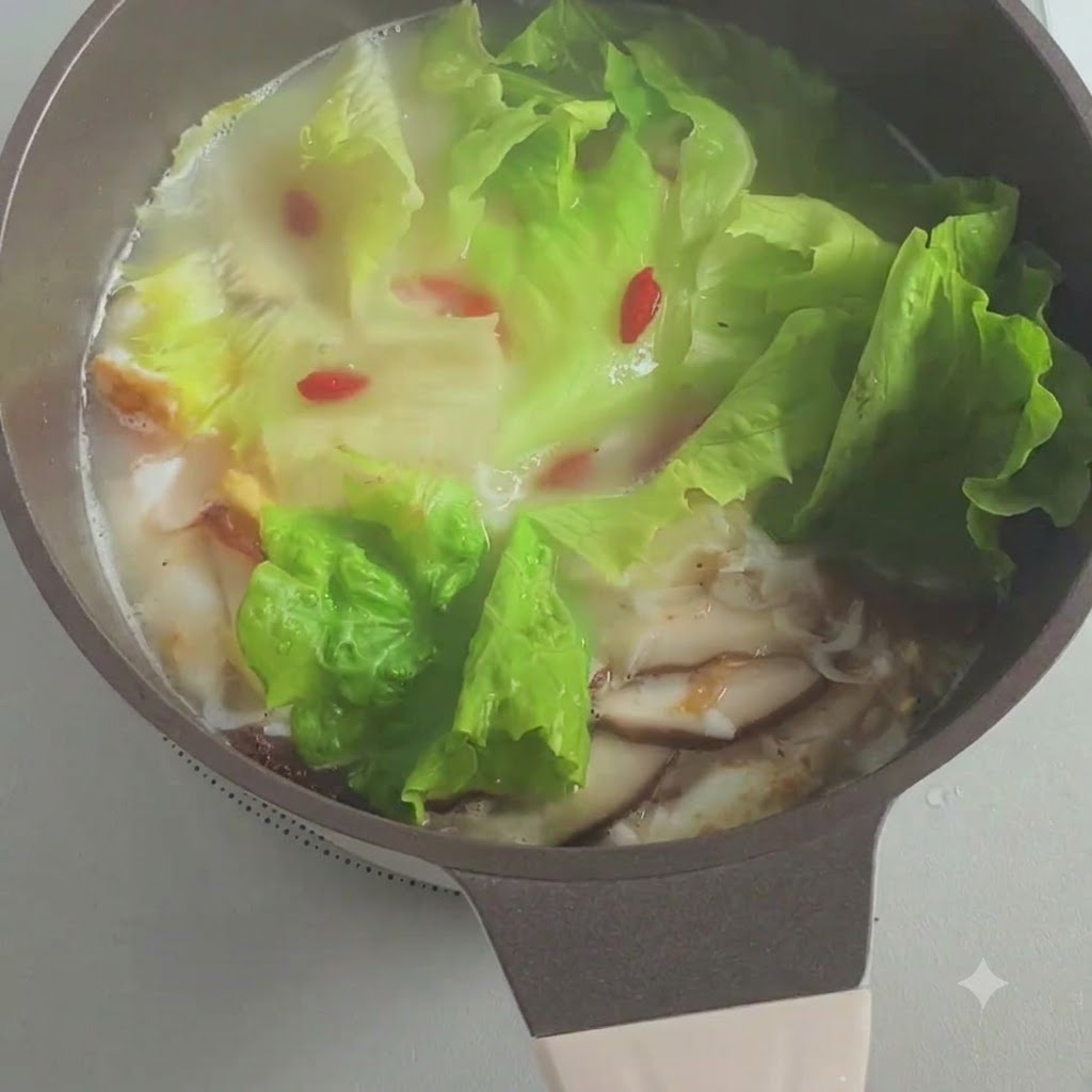 Cébettes hachées parsemées dans la marmite de soupe frémissante.
