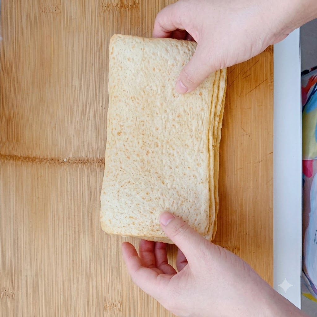 Gâteaux de poisson découpés en grands rectangles sur une planche à découper en bois.