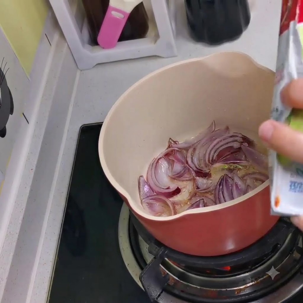 Du kimchi versé dun sachet dans la casserole contenant les oignons rouges sautés.